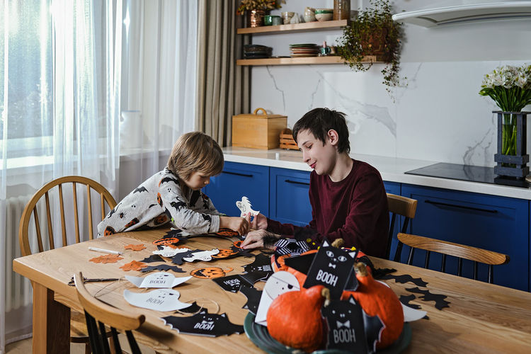 Side view of mother and daughter sitting on sofa at home