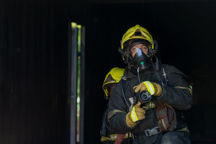 Portrait of firefighter against black background