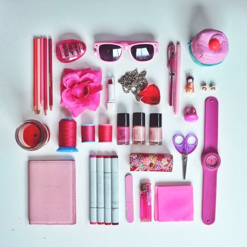 Collection of pink accessories arranged in order for personal use