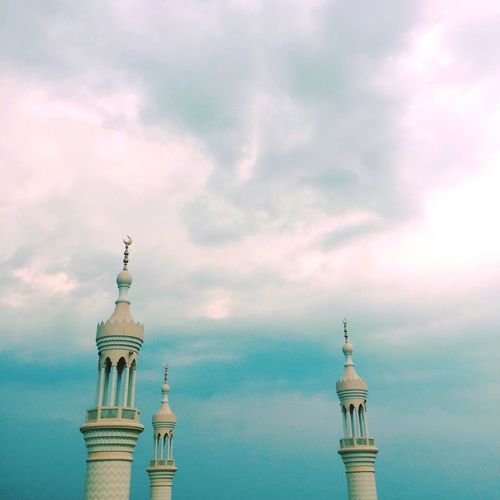 Low angle view of masjid sheikh zayed mosque minarets against cloudy sky