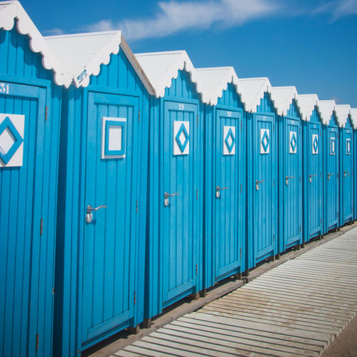 Beach huts lined up in a beautiful blue color