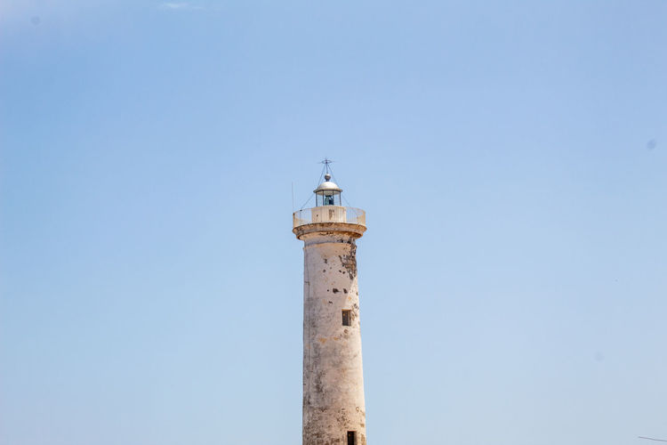 A lighthouse stands out in a cloudless sky