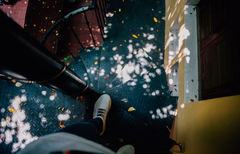 Low section of person standing on spiral staircase