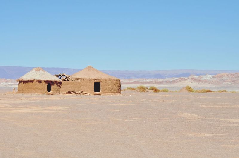 Built structure on desert against clear blue sky