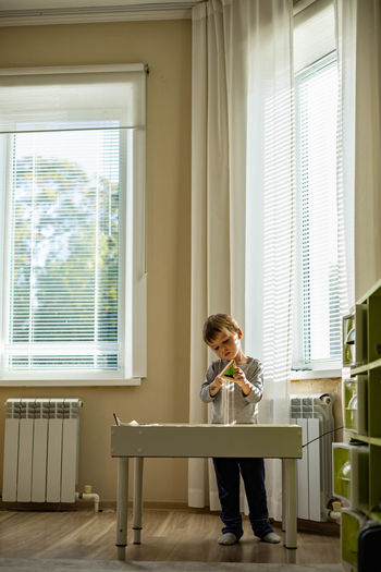 Boy playing with window at home