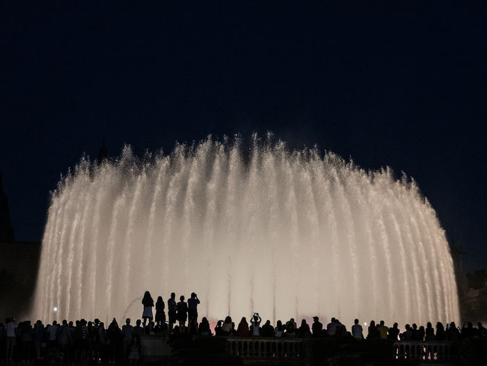 Low angle view of illuminated fountain against sky at night