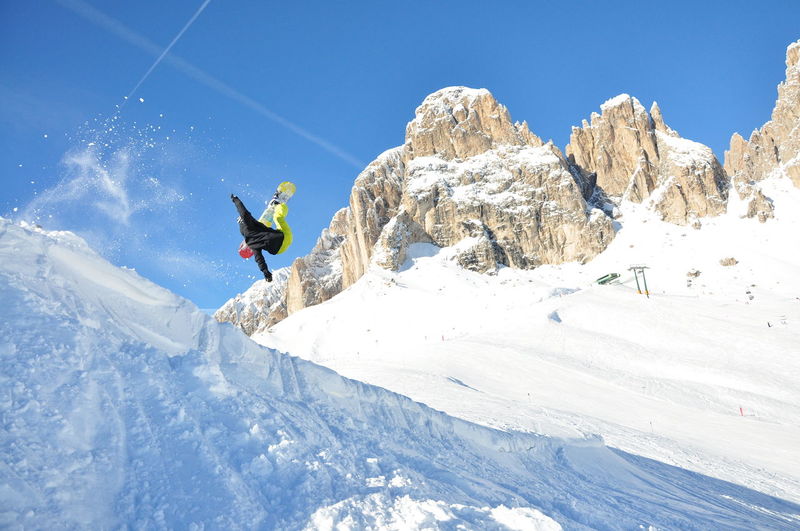 Man snowboarding on snow against sky