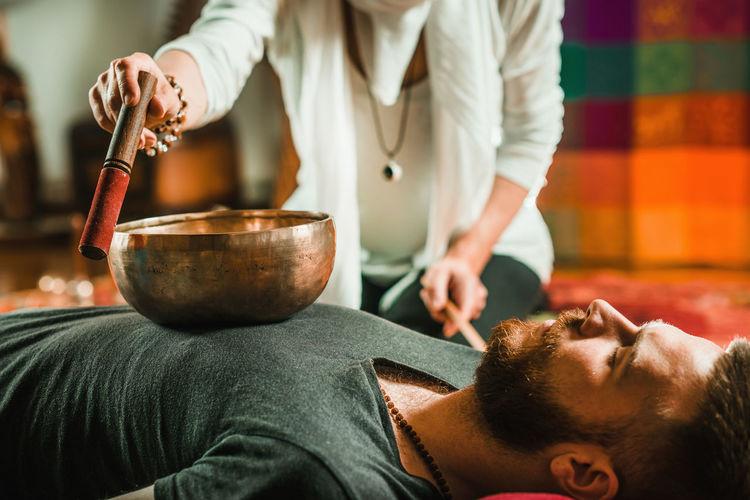 Therapist playing rin gong while performing music therapy at spa