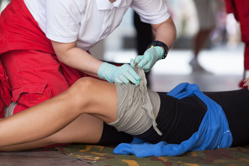 Paramedic tying bandage on leg