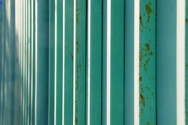 Green and blue metal fence background, close-up
