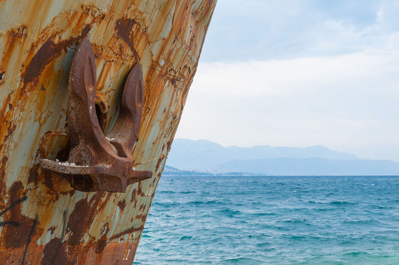 Close-up at the bow of corroded and abandoned shipwreck washed ashore.