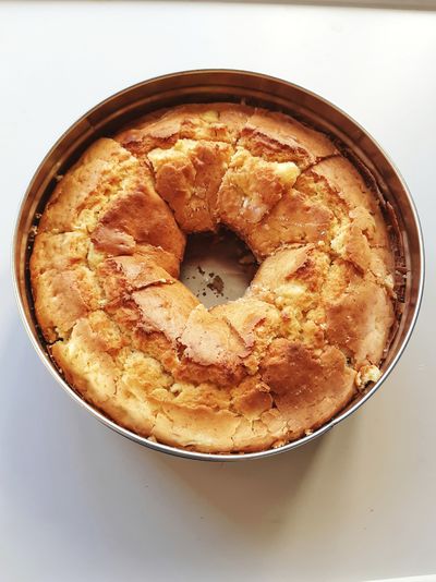A homemade italian cake in the shape of a donut,inside a tin box 