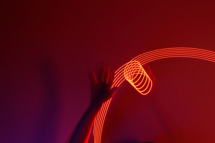 Close-up of hand against light painting 