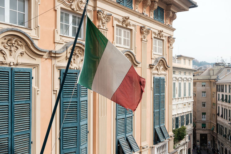 Close-up of italian flag against building in city