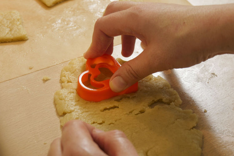 Cropped hands of person with heart shape cookie cutter