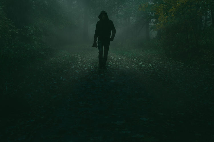 Silhouette man walking in forest