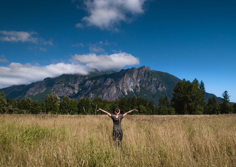 Woman standing on field against mountain