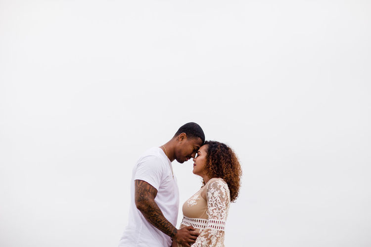 Mixed race couple embrace maternity photos
