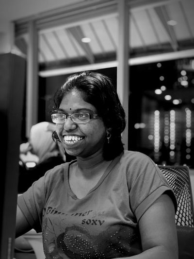 Smiling woman wearing eyeglasses looking away while sitting on chair