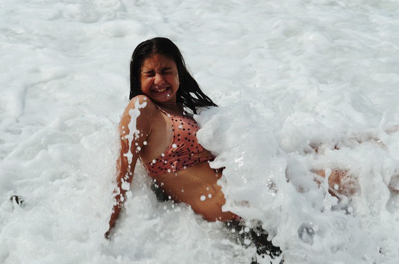 Full length of smiling woman in water