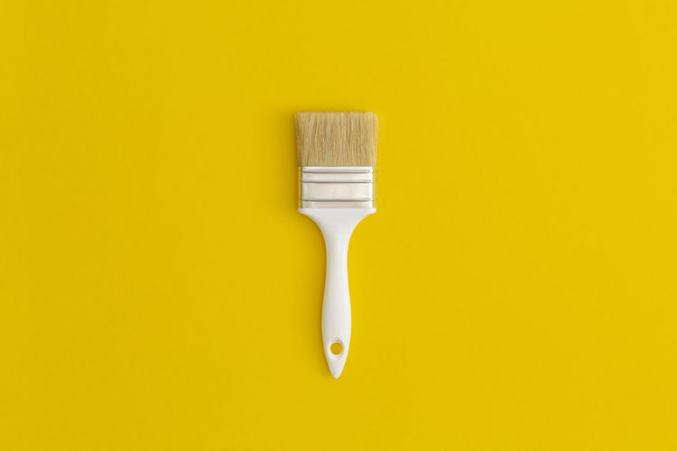 Paint brush on yellow background.