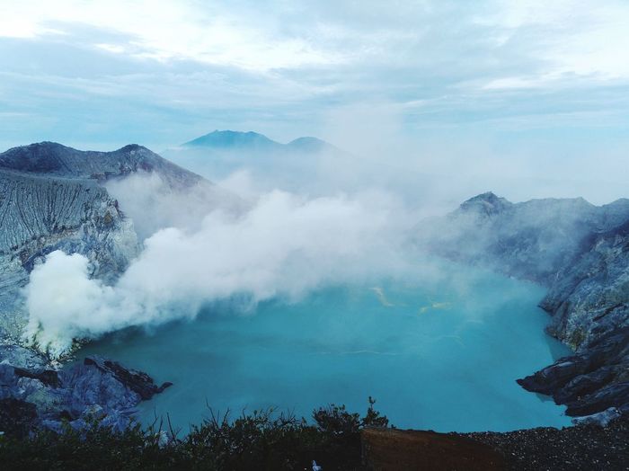 Smoke emitting from volcanic mountain against sky