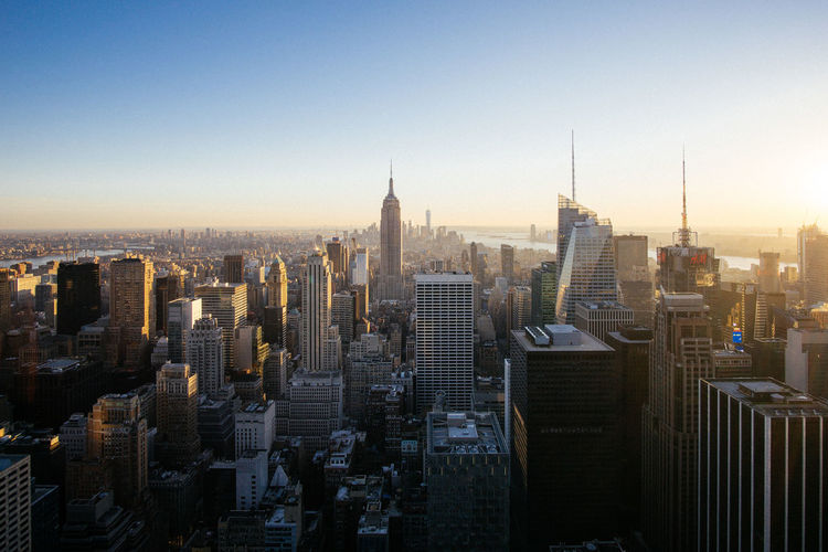 High angle view of cityscape with empire state building against clear sky during sunset