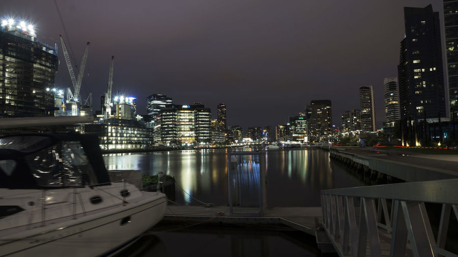 Boat moored at harbor in city at night