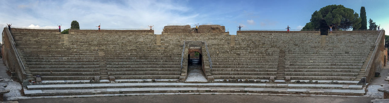 Low angle view of woman standing on steps of the theater of ostia antica