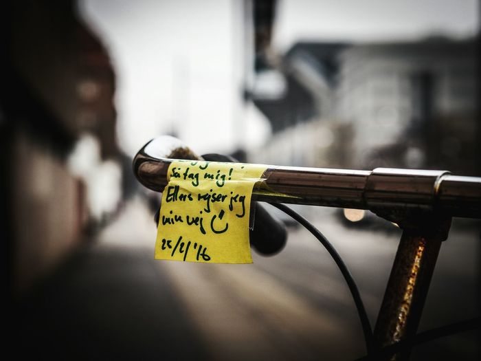 Close-up of adhesive note on bicycle handle