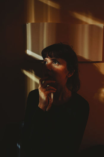 Portrait of worried woman sitting at home