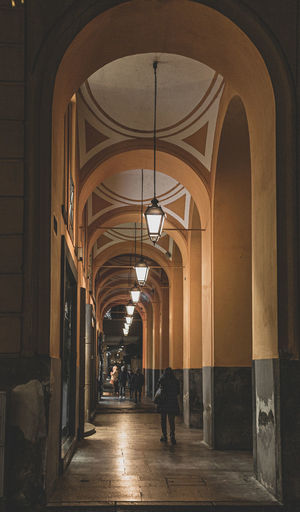 Rear view of people walking in corridor of building