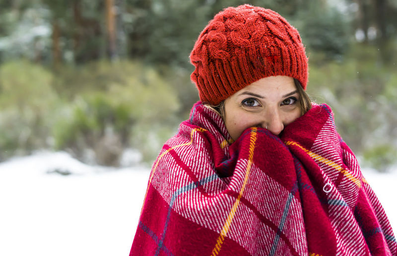 Portrait of young woman wearing blanket during winter