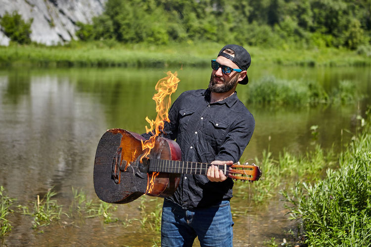 Man playing guitar in lake