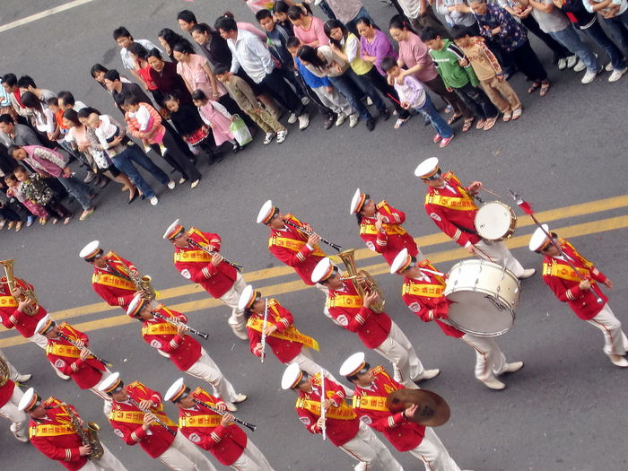 High angle view of marching band by crowd on street during traditional festival