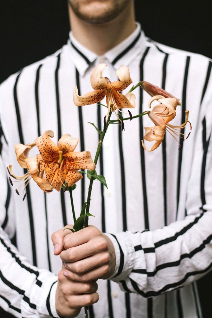 Midsection of man holding flowers