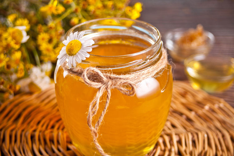Close-up of yellow glass in jar on table