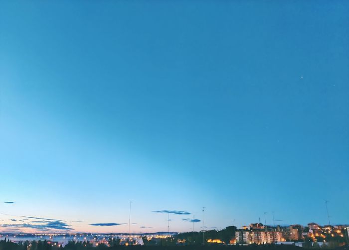 High angle view of buildings against clear blue sky