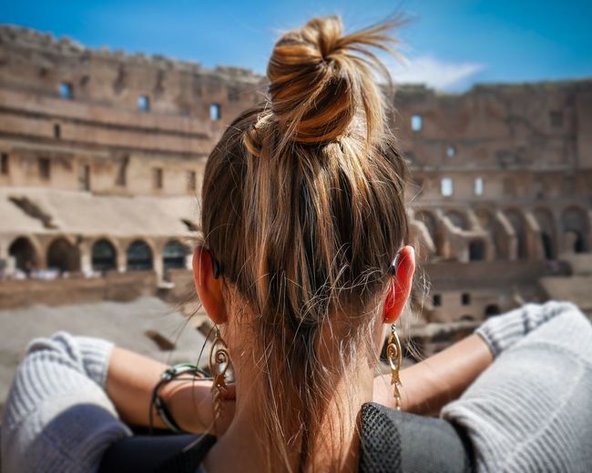 Rear view of woman in front of coliseum