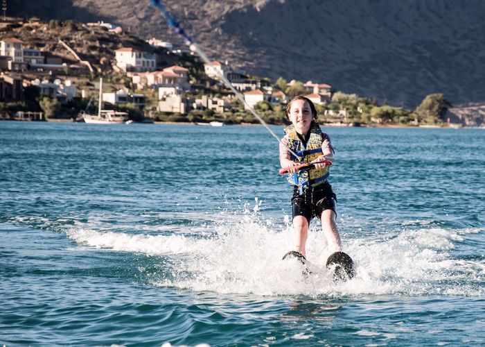 Full length of boy wakeboarding in sea