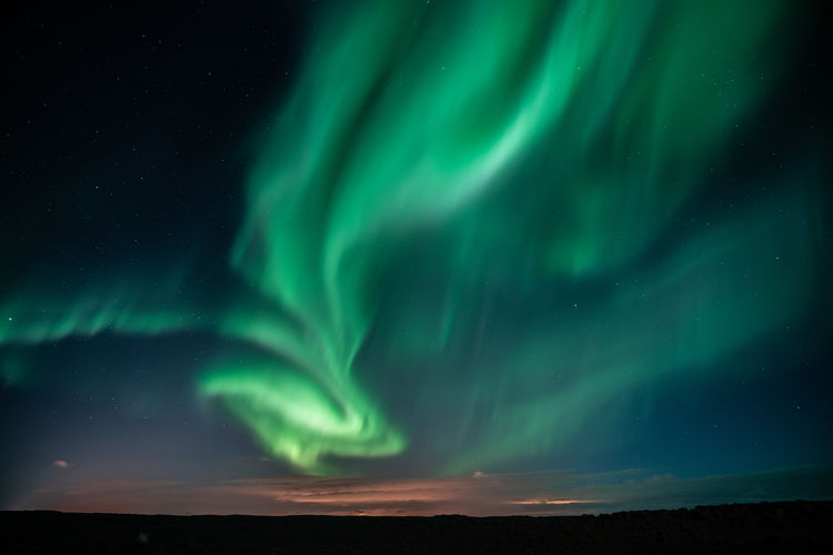 Green landscape against sky at night