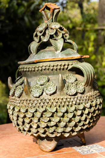 Close-up of antique urn on table
