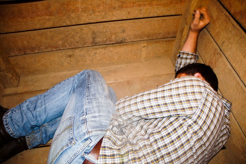 Man lying down in wooden container