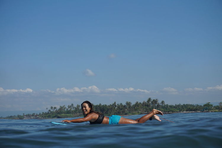 Portrait of happy woman surfing in sea 