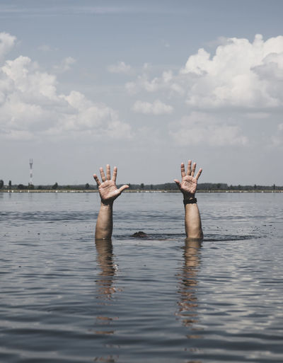 Cropped image of man drowning in sea