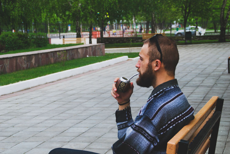 Young man drinking mate tea outdoors