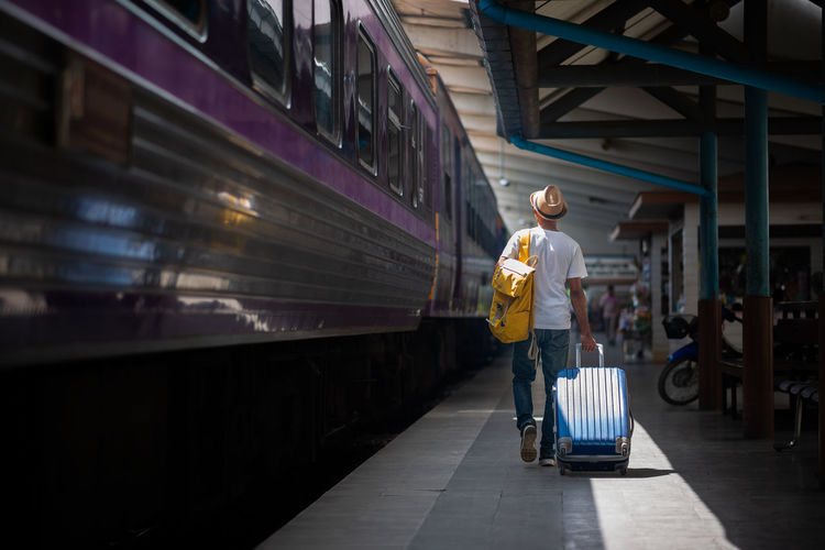 Traveler waits train at train station for travel in summer. travel concept.