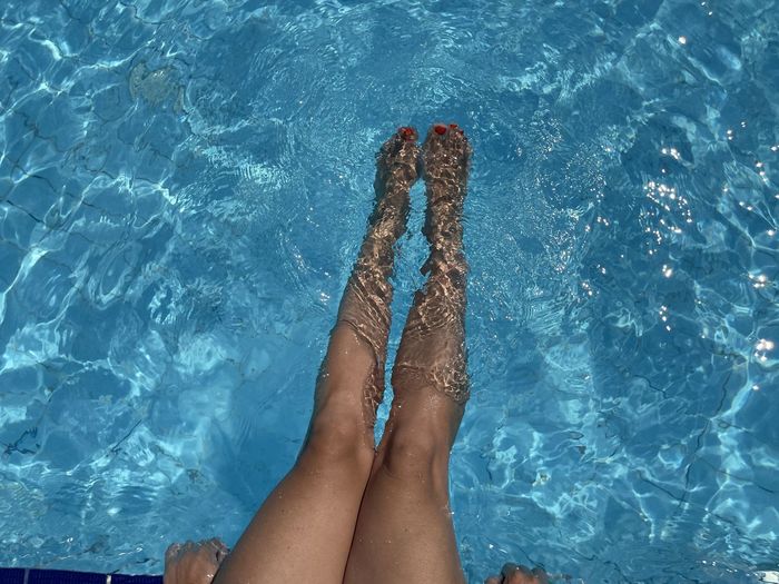 Close up woman feet in swimming pool.summer holiday concept.