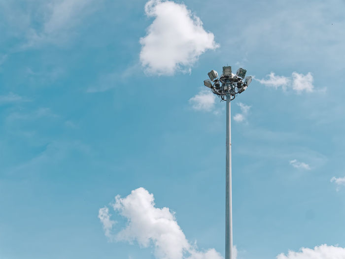 Low angle view of street lamps at top of the post against blue sky