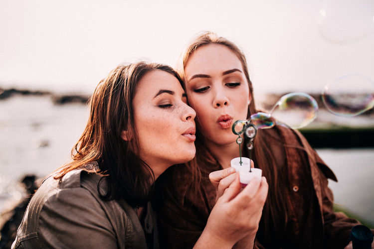 Close-up of young women blowing bubbles